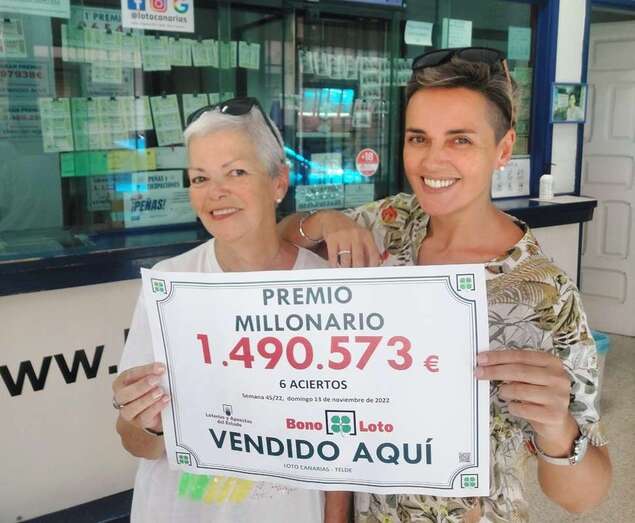 Cecilia Díaz (d) portando el cartel del premio vendido en su negocio/TA.